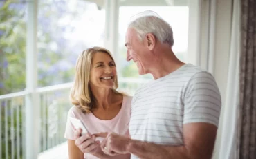 happy-senior-couple-interacting-with-each-other-balcony